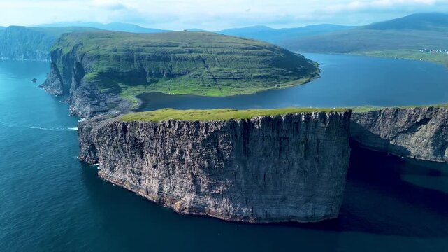 Explore the stunning cliffs and lush landscapes of the Faroe Islands. The aerial perspective reveals the mesmerizing contrasts between sea and land, showcasing natures untouched beauty and allure.
