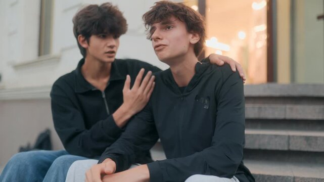 Teenager comforts upset friend in city street, showing youth compassion