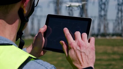 A man operates a drone using a tablet, navigating the drone with precise gestures. The man's tablet reflects a map while the drone flies steadily over the grassy landscape. - Powered by Adobe