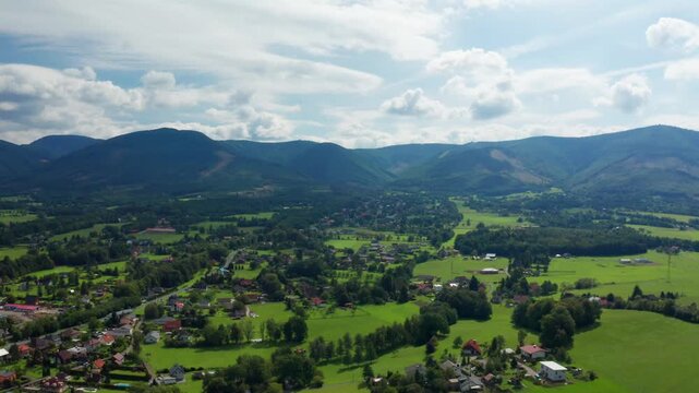 Right side drone shot of czech small village with beskydy mountains