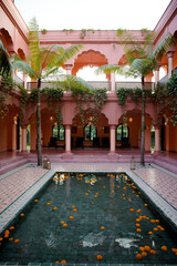 pink building design structure with a pool, trees, and lamps