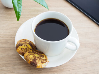 テーブルの上のホットコーヒーとクッキー、タブレット