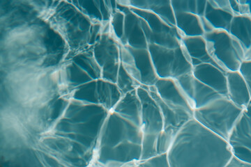 Swimming pool with clear blue water with sunlight shadow reflections. Minimalistic aesthetic summer vacation concept background	