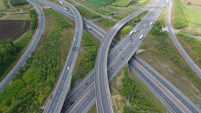 Aerial view of the M6 Junction 1 interchange creating a network of curving highways and overpasses, showing the intricate design of modern transportation, Rugby, England, United Kingdom.