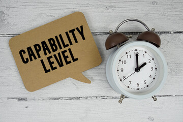 Capability Level text with alarm clock on wooden background