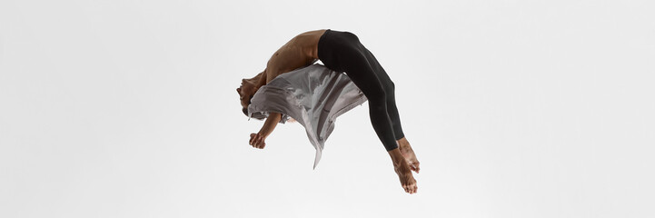Male dancer arching body midair in coat with expressive intensity and dramatic release. Concept of music visuals, performance art, body storytelling, and emotional exploration. Banner
