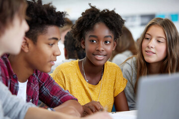 Group of students working on a project, engaged in conversation and collaborating. Studying, learning, and teamwork in action.
