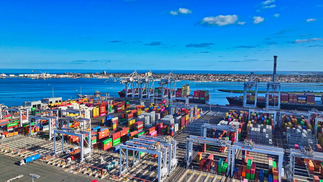 Stacked shipping containers at busy Webb Dock terminal