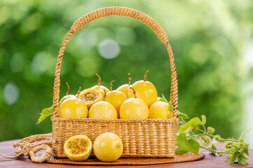 Yellow Passion fruit with leaf in basket on green nature bokeh background, Fresh Passion fruit or Maracuja in wooden table on blur background.
