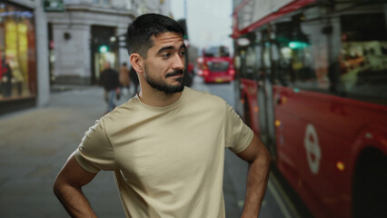 Fototapeta premium Young man standing confidently in an urban street with a background of iconic red buses, showcasing a charming smile and relaxed posture in a cosmopolitan city scene
