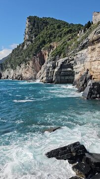 onde sbattono su scogliera con insenature e grotte, golfo dei poeti, mare mediterraneo