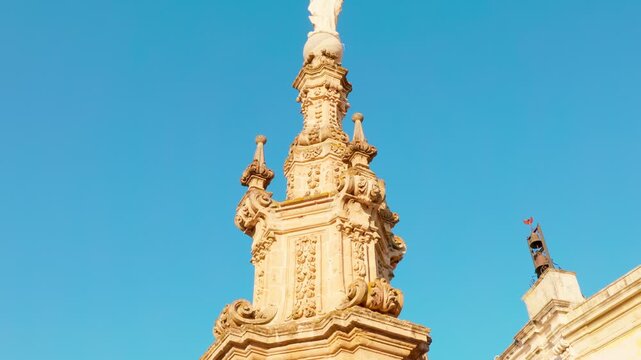 Low-angle upward tracking shot of the Immaculate Conception Spire in Piazza Salandra, Nard&ograve;, enhancing its vertical grandeur