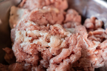 Fresh raw ground meat in a bowl for preparing delicious homemade cutlets, highlighting quality...