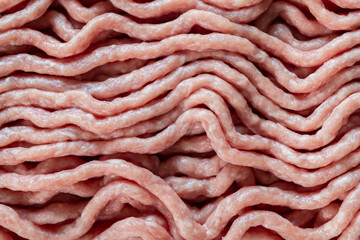 Fresh raw ground meat with a light pink, wavy texture, an essential ingredient for home cooking, restaurant food preparation, and diverse culinary dishes