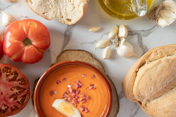 Spanish salmorejo with ingredients on marble table