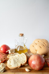 Ingredients for preparing salmorejo, tomatoes, garlic, bread and olive oil on wooden board