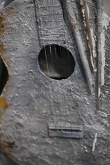 A close-up shot of a damaged guitar with a hole in the body