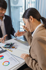 Business colleagues are engaged in a financial meeting, reviewing colorful charts and reports. They exchange ideas, make notes, and analyze strategies to achieve effective results.