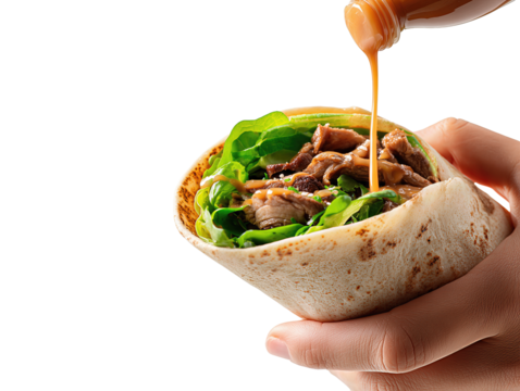 
Hand assembling wrap → three-quarter, open flatbread filled with greens and meat while squeeze bottle drizzles sauce, tight framing → isolated on transparent white background, no shadow or reflection