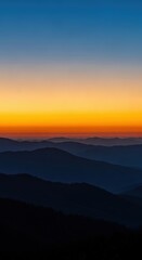 Fototapeta premium Majestic sunset over layered mountain peaks with soft gradient sky