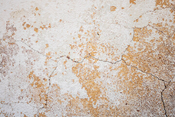Peeling plaster and paint on the wall as a neutral, calm abstract background.