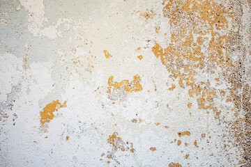 Peeling plaster and paint on the wall as a neutral, calm abstract background.