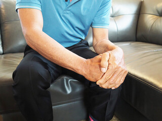 Asian man in suffering from knee pain at home, Health concept.