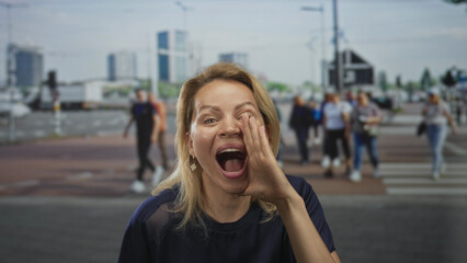 Fototapeta premium Woman blonde cups hand to mouth shouting on busy city street at daylight; urgent announcement excitement.