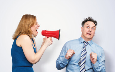 Funny scene of a woman yelling through a megaphone at a terrified man in a shirt and tie. Humorous...