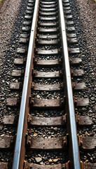Fototapeta premium Top-down view of reflective train tracks with sleepers and gravel ballast 