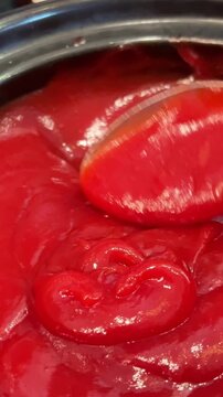 scoop ketchup with a spoon hand stirs fish soup with a tablespoon in a white plate with wide sides and places a piece of grilled bread on it. Vertical video. High quality 4k footage