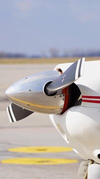 Front part of the little plane. Propeller starts to rotate. Aircraft on the empty aerodrome. Vertical video