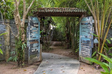 old blue wooden door in tropical garden