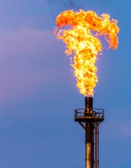Industrial flare stack ablaze at dusk