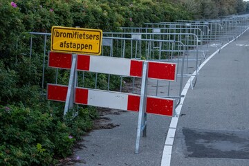 Crowd control barriers and sign indicating dismounting for moped riders in dutch