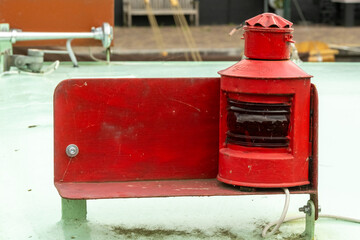 Red navigation light standing on boat deck