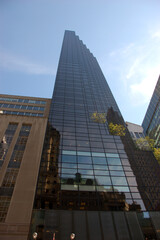 The Trump Tower in New York City, a tall modern skyscraper with reflective glass façade, rising...