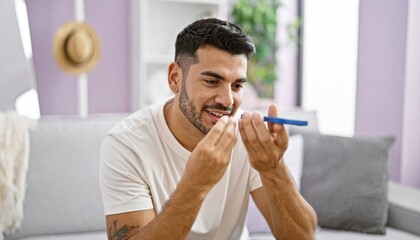 Young man recording voice message via smartphone at home