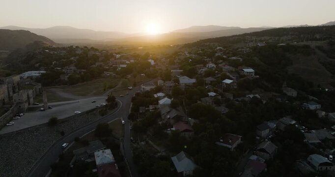 Aerial view of Rabati Castle and the surrounding town nestled in the hills, with the sun rising in the distance, Akhaltsikhe, Samtskhe-Javakheti, Georgia.