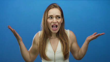 Woman with long hair in white sleeveless top shrugs shoulders with both arms raised, mouth open and...
