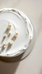 Top-down close-up of an elegant wedding cake with smooth frosting and minimal decor.
