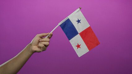 Caucasian man holding panama flag against pink background with isolated hand prominently displayed.