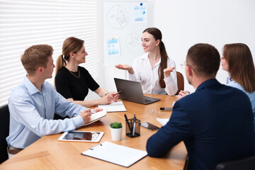 Business coach giving presentation to group of people in office