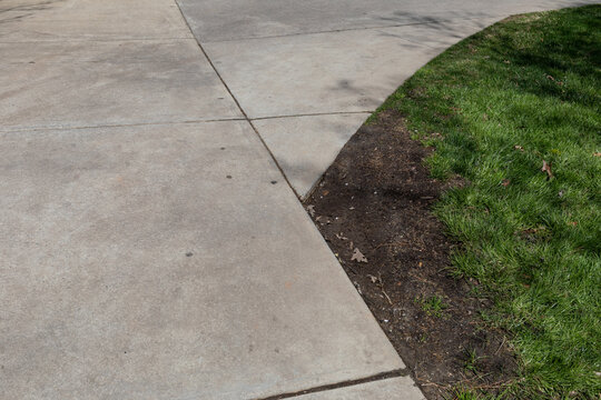 Concrete walkway with muddy shortcut corner, cutting corners metaphor, creative copy space, horizontal aspect