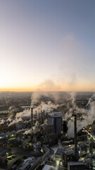 Visão aérea indústria de papel e celulose com chaminés e galpões em funcionamento.