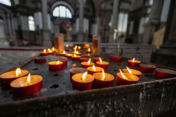 Votive candles burning inside the church of San Giorgio Maggiore, Venice, Italy