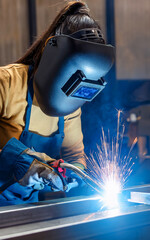 worker manually welds steel and stainless steel components using TIG technology, detail of an electric arc