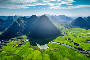 Aerial view of beautiful Bac Son Valley with lush rice field, mountain range, winding river and rural village in countryside at Lang Son, Vietnam