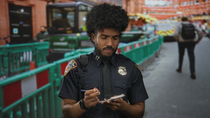 Police officer writing notes at a busy construction site outdoors, wearing a badge and uniform, surrounded by urban scenes, barriers, and machinery in the background.