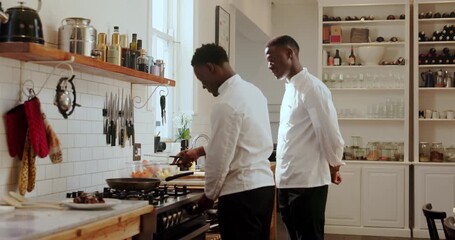 Chef, cooking and men with training in kitchen for recipe guidance, technique or support. Culinary intern, mentor or black people with lesson in restaurant for food preparation, knowledge or learning
